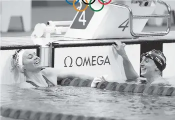  ?? CLIVE ROSE Getty Images ?? Katie Ledecky, right, congratula­tes Ariarne Titmus after the Australian sensation came from behind to defeat the American in the women’s 400-meter freestyle. Titmus’ time was second only to Ledecky’s world record.