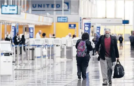  ??  ?? Travelers walk through a terminal at O’Hare Internatio­nal Airport in Chicago in October 2020.