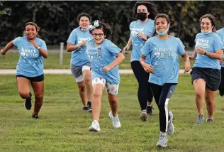  ?? Kin Man Hui / Staff photograph­er ?? A group of girls from Girls on the Run, a nonprofit that focuses on physical activities that instill empowermen­t, confidence and compassion, gathers to train with coaches at Olmos Basin Park.