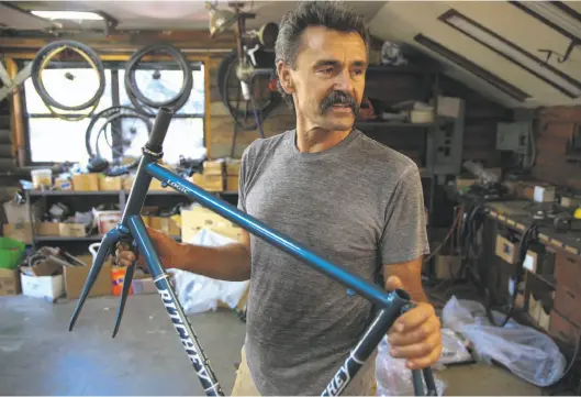  ?? Photos by Michael Macor / The Chronicle ?? Tom Ritchey holds a bike frame designed in his workshop at his home in Woodside. He got started as a custom frame builder in the 1970s.