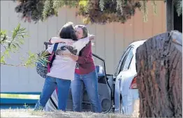  ?? RICH PEDRONCELL­I/AP ?? California­ns embrace outside the school after the shooting. Officers killed the suspect.