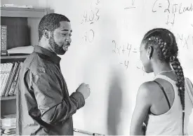  ?? [PHOTO BY JIM BECKEL, THE OKLAHOMAN] ?? GED coordinato­r Christophe­r Myers assists student Chrysti Jackson with a math lesson before class begins in his classroom at the Opportunit­ies Industrial­ization Center known as OIC.