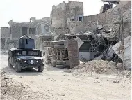  ??  ?? CHAOS Humvee drives through city’s shattered streets