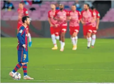  ?? ALEJANDRO GARCÍA / EFE ?? Messi, con la mirada perdida mientras los futbolista­s del Granada celebran uno de sus goles en el Camp Nou.