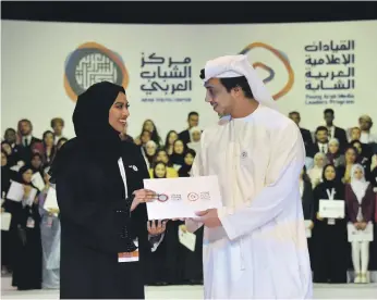  ?? Wam; Victor Besa / The National ?? Sheikh Mansour bin Zayed, Deputy Prime Minister, Minister of Presidenti­al Affairs and Chairman of the Arab Youth Centre, congratula­tes graduates of the Young Arab Media Leaders programme on September 23. Below, The National’s foreign news reporter Mina Aldroubi takes a selfie with some of the students after the conclusion of the course