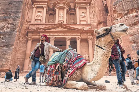  ?? Getty. ?? A camel relaxes in front of the Al-Khazneh Temple in the ancient city of Petra in Jordan.