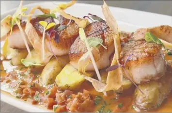 ?? Lori Van Buren / Times Union ?? Pan-seared scallops, herb-roasted fingerling potatoes, parsnip and butternut crisps, lobstershe­rry-butter sauce at Daley’s on Yates.