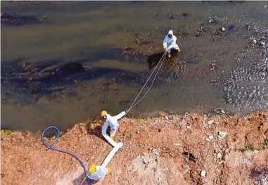  ?? PIC BY KHAIRUL GHAZALI ?? Contractor­s cleaning up Sungai Kim Kim in Pasir Gudang yesterday.