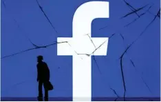  ?? — AFP photo ?? File photo shows a figurine standing in front of the logo of social network Facebook on a cracked screen of a smartphone in Paris.