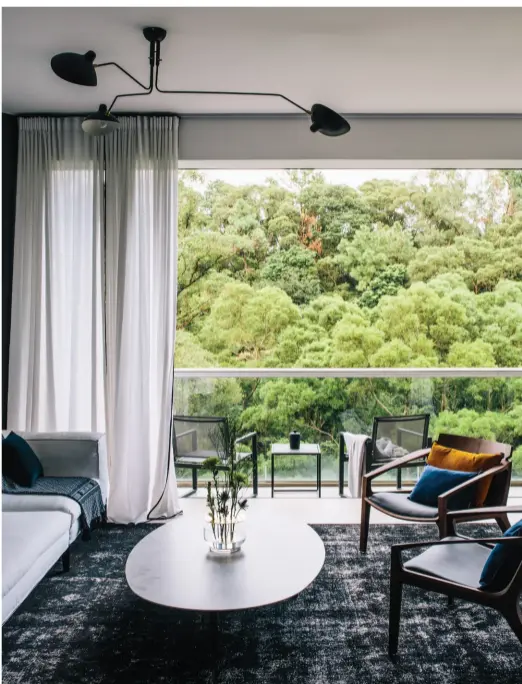  ??  ?? features floor-to-ceiling windows that open fully to draw the surroundin­g greenery into the living space