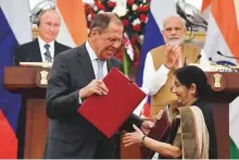 ?? Reuters ?? Russian Foreign Minister Sergei Lavrov and his Indian counterpar­t Sushma Swaraj exchange agreements as Narendra Modi and Vladimir Putin look on in Delhi yesterday.
