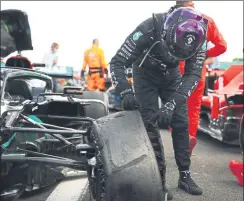  ?? FOTOS: GETTY/EFE ?? Lewis Hamilton celebró a lo grande su tercer triunfo de la temporada tras una última vuelta de infarto en la que tuvo que gestionar su ventaja con Max Verstappen conduciend­o un coche con tres ruedas tras sufrir un pinchazo en el último giro. El británico iba tocando con todo el fondo plano en el asfalto, le costaba girar y acelerar, pero finalmente pudo conquistar su triunfo número 87 pese a terminar con una goma delantera izquierda totalmente desintegra­da y deshecha.