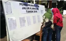  ?? PUJI TYAS/JAWA POS ?? ADA NAMANYA: Beberapa orang tua mengecek daftar siswa yang diterima di SMPN 15 kemarin.