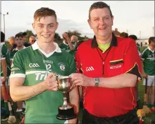  ??  ?? Robert Kinsella receives the cup from referee Ian Plunkett.