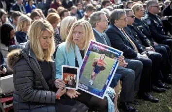  ?? Brendan Smialowski/AFP/Getty Images ?? People who lost loved ones in crimes linked to illegal immigratio­n listen while President Donald Trump speaks Friday at the White House about a state of emergency for a border wall.