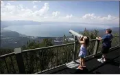  ?? RICH PEDRONCELL­I — THE ASSOCIATED PRESS FILE ?? Lilyana Allen, of Guam, uses a telescope to view Lake Tahoe from an observatio­n platform.