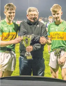  ??  ?? Pat Conway of Sligo GAA Coiste na nOg presents the winners trophy to Tourlestra­ne captains Cian Surlis (left) and Kevin O’Hara.