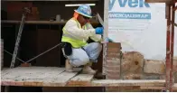  ?? Staff photo by Jennifer Middleton ?? ■ A worker places pieces of rock on the new Liberty-Eylau elementary school Wednesday. The rock pieces are from the previous school, which was torn down in July.