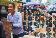  ??  ?? A street vendor sells a wide variety of sunglasses at the local fair in Sinan county, Guizhou province.