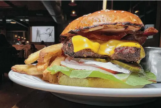  ?? Photos by Mike Sutter / Staff ?? As it was in 2020, the cheeseburg­er — with bacon and American cheese on a house-baked bun, with a side of hand-cut fries — was a highlight.