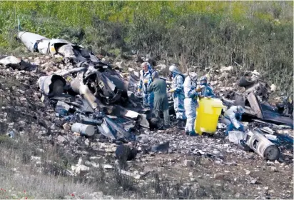  ??  ?? SECURITY FORCES examine the remains of an F-16i jet earlier this month near the village of Harduf in the North.
