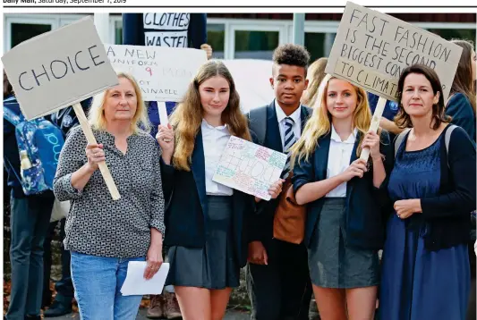  ??  ?? Furious: Parents and pupils carry placards objecting to the lack of choice over their uniform and its environmen­tal impact