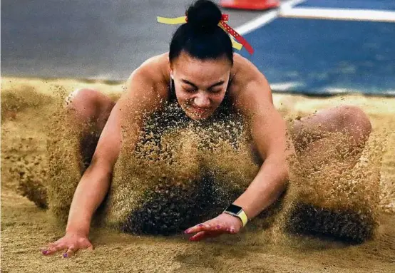  ?? JOHN TLUMACKI/GLOBE STAFF ?? Cardinal Spellman’s Annaikiah Donahue-Wilfred sticks her landing in the girls’ long jump, placing eighth in 17 feet, 4 inches.