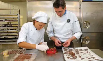  ?? FOTO: BERND F. MEIER ?? In Florenvill­e stellen Meister-Chocolatie­r Edouard Bechoux (r.) und seine Auszubilde­nde Rita Pralinen her.