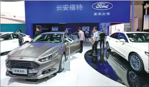  ?? ZHANG HAIYAN / CHINA DAILY ?? Changan Ford’s booth attracts visitors at an auto show in Beijing.