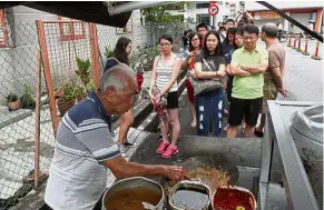  ??  ?? char koay teow. A long line of customers queuing up for a taste of Tan’s Brisk business: