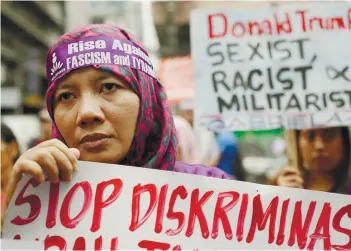  ?? AP FOTO ?? RALLY. Nur, a protester from Indonesia, holds a sign during a rally as they tried to march near the U.S. Embassy in Manil to protest the upcoming visit of U.S. President Donald Trump.