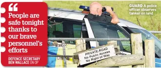  ??  ?? GUARD A police officer observes tanker on land