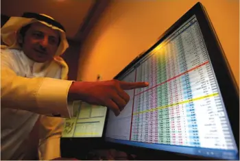  ?? (Faisal Al Nasser/Reuters) ?? AN INVESTOR gestures as he monitors a screen displaying stock informatio­n in Riyadh on Monday.