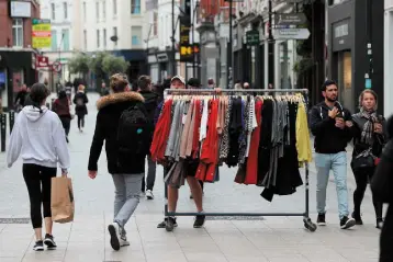  ??  ?? PREPARATIO­N: A man wheels a rack of clothing down Grafton Street in Dublin yesterday as phase two of Ireland’s coronaviru­s recovery road map is set to begin. Photo: Brian Lawless