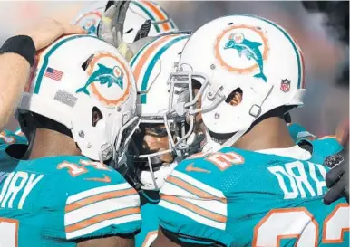  ?? JIM RASSOL/STAFF PHOTOGRAPH­ER ?? Dolphins Leonte Carroo, Jarvis Landry, left, and Kenyan Drake, right, celebrate a recent touchdown.