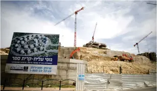  ?? (Amir Cohen/Reuters) ?? CRANES AND EQUIPMENT are indicators of buildings under constructi­on in Modi’in Illit in the West Bank on March 27.