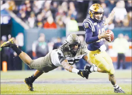  ??  ?? In this file photo, Navy quarterbac­k Malcolm Perry Army runs past defensive lineman Edriece Patterson during the second half of an NCAA college football game, in Philadelph­ia. Perry, drafted by the Miami Dolphins, will be able to turn pro in 2020 thanks to a policy change initiated by President Donald Trump. New guidelines issued in November 2019 allow service academy graduates to seek delaying their military commitment in order to play pro sports, and
Perry’s request for a waiver is expected to be granted. (AP)