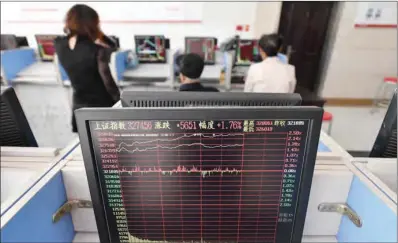  ?? (AFP) ?? Investors look at stock prices at a brokerage in Fuyang, in China’s eastern Anhui province recently.