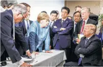  ?? Jesco Denzel / New York Times ?? With other officials looking on, German Chancellor Angela Merkel speaks to President Donald Trump during the second day of the G-7 summit meeting in La Malbaie, Quebec.