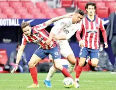  ??  ?? Real Madrid’s midfielder Casemiro (right) challenges Atletico Madrid’s midfielder Saul Niguez during the Spanish league football match Club Atletico de Madrid against Real Madrid CF on Sunday. - AFP photo