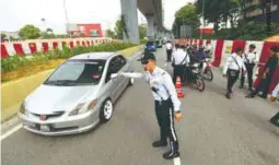  ??  ?? ... Police personnel flagging down a motorist during an operation in Kota Damansara, Petaling Jaya yesterday. Selangor police issued 1,169 summonses during a state-wide operation at 16 locations, codenamed ‘Red Light Operation’.