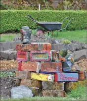  ??  ?? A colourful brick and boot sculpture with the new slate ‘herb spiral’ behind.
