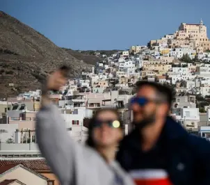  ?? David Gannon, AFP via Getty Images ?? People pose for a selfie on the upper deck of a ferry from the port of Piraeus in Athens to the Island of Mykonos, Greece, stopping here at Siros Island on Oct. 4, 2020.