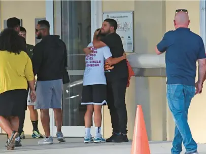  ?? JOHN MCCALL/SOUTH FLORIDA SUN SENTINEL ?? People embrace Monday outside the Sunset Lakes Community Center where grief counselors met with friends of 15-year-old Achilles Lopez, who was unintentio­nally shot and killed by a family member on Sunday.