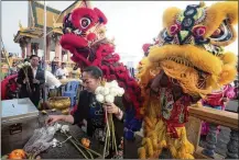  ?? AP ?? CAMBODIA: Members of the Cambodian Chinese community dance Friday in front of Royal Palace in Phnom Penh, ahead of the new year.