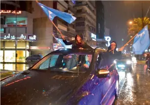  ??  ?? Supporters of Saad Hariri wave the Future Movement flags in Beirut as they celebrate his return. —