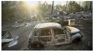  ?? — AP ?? Burnt out shell: A vehicle scorched by a wildfire in a clearing on Wolf Creek Road near Clearlake Oaks.