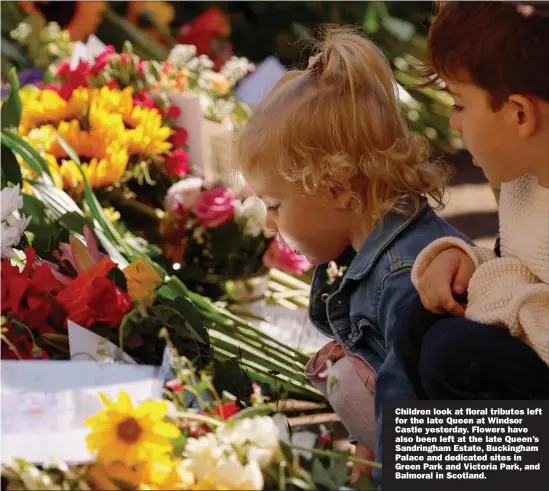  ?? Picture: ANDREW COULDRIDGE/REUTERS ?? Children look at floral tributes left for the late Queen at Windsor Castle yesterday. Flowers have also been left at the late Queen’s Sandringha­m Estate, Buckingham Palace and dedicated sites in Green Park and Victoria Park, and Balmoral in Scotland.