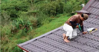  ?? Photo by Jean Nicole Cortes ?? BEFORE THE STORM. A home owner at Tuba, Benguet repairs his roof as a preemptive measure before Typhoon Ompong arrives in the highlands as several municipali­ties in the province have already declared pre-emptive evacuation.