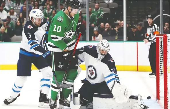  ?? RONALD MARTINEZ/GETTY IMAGES FILES ?? Goalie Connor Hellebuyck foils Dallas Stars shooter Corey Perry in front of the net in what’s become a familiar scene for the Jets this season.